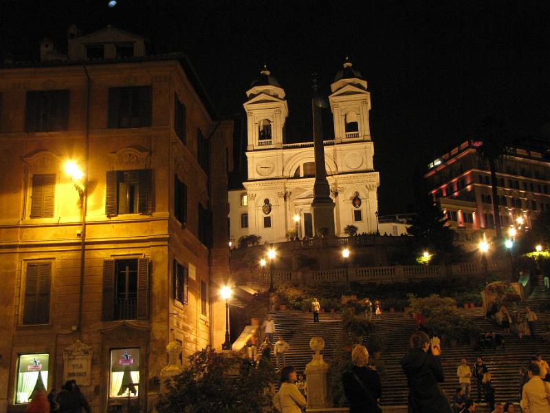 trinita dei monti_boven_spaanse trappen.jpg - De Spaanse trappen bij avond. De kerk boven aan de trappen is de Trinitá dei Monti. De kerk is gebouwd in opdracht van Lodewijk XII van Frankrijk. Ook de trappen zijn betaald door Fransen. De trappen leiden vroeger echter naar de spaanse ambassade, daarvandaan de naam. Let in de foto even op alle bloemen die op de trappen staan. Een paar dagen later, toen we met de kinderen hier weer kwamen, waren alle bloemen weg.
